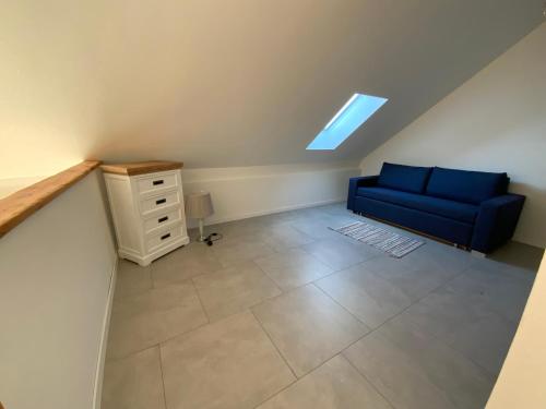 a living room with a blue couch and a table at Well-being in Eifel in Nettersheim