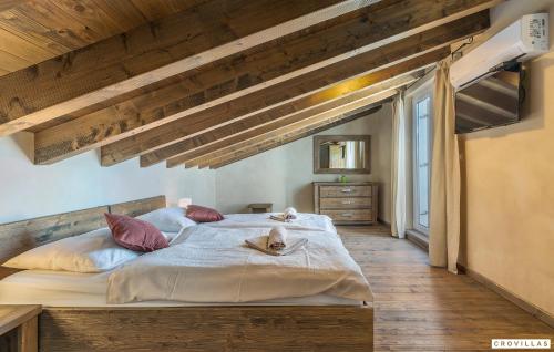 a large bed in a room with wooden ceilings at Nocciola in Premantura
