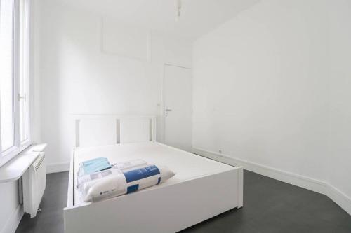 ein weißes Bett in einem Zimmer mit Fenster in der Unterkunft Montrouge 1 Bedroom Flat 30m2 - (2 pièces) in Montrouge