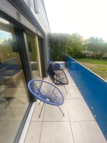 two chairs sitting on the balcony of a building at Lake View Penthouse in Hajdúszoboszló