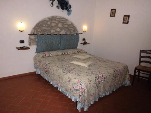 a bedroom with a bed with a large bedspread at Agriturismo La Castellina in Saturnia
