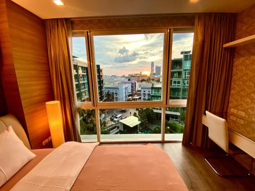 a bedroom with a large window with a view of a city at Lux SL Luxury Style of Life in Pattaya