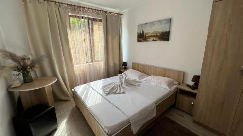 een kleine slaapkamer met een bed en een raam bij Complex Stoican in Băile Herculane
