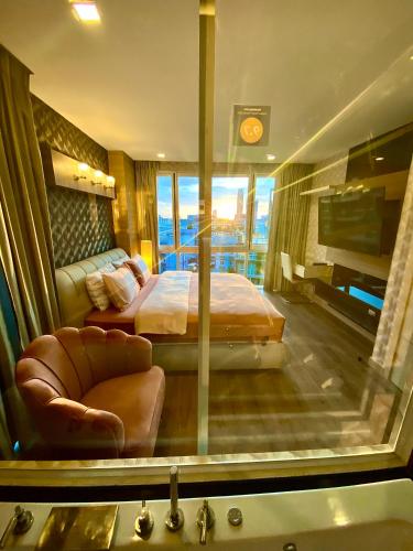 a bedroom with a bed and a chair in a room at Lux SL Luxury Style of Life in Pattaya Central