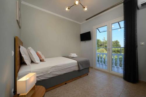 um quarto com uma cama e uma grande janela em Villa Alina em Lefkimmi