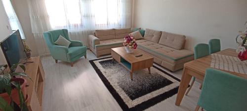 ein Wohnzimmer mit einem Sofa, Stühlen und einem Tisch in der Unterkunft SOYLU Suites in Trabzon