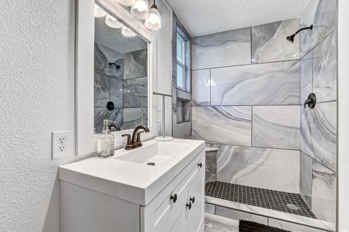 ein weißes Bad mit einem Waschbecken und einer Dusche in der Unterkunft Lake View Retreatpool10qn Beds in Orange Park
