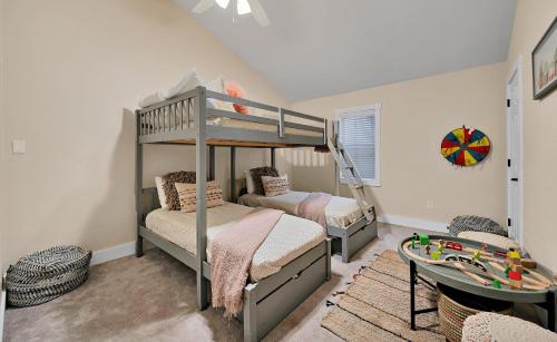 a bedroom with two bunk beds and a table at The Farmhouse 20 Min to Magnolia and Baylor in Waco