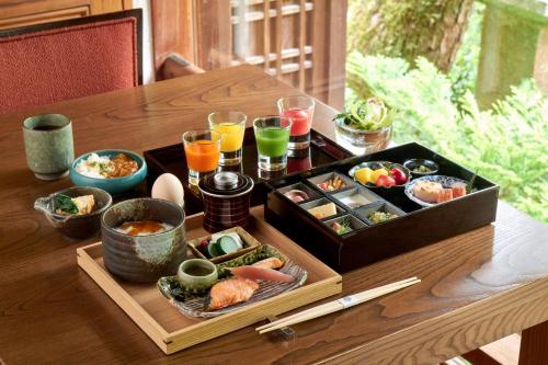 Una mesa de madera con una bandeja de comida y bebidas. en Suiran, a Luxury Collection Hotel, Kyoto, en Kioto
