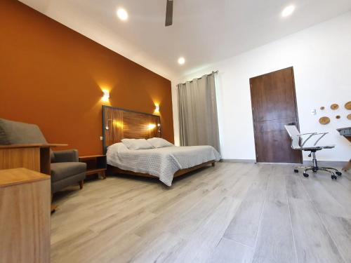 a bedroom with a bed and a chair and a couch at Hotel Camino del Bosque Atlixco in Atlixco