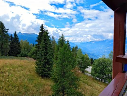 une vue depuis une maison sur les arbres et les montagnes dans l'établissement Arc 1800 - Studio 5p - Réservations du Samedi au Samedi uniquement, à Arc 1800