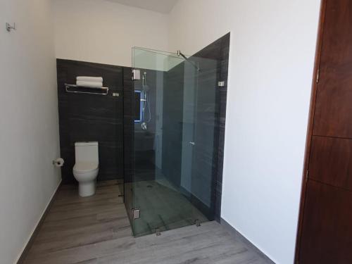 a bathroom with a glass shower and a toilet at Hotel Camino del Bosque Atlixco in Atlixco