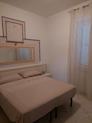 ein weißes Schlafzimmer mit einem Bett und einem Fenster in der Unterkunft CASA DEL SOLE in Ischia