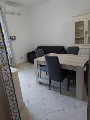 ein Wohnzimmer mit einem Holztisch und Stühlen in der Unterkunft CASA DEL SOLE in Ischia