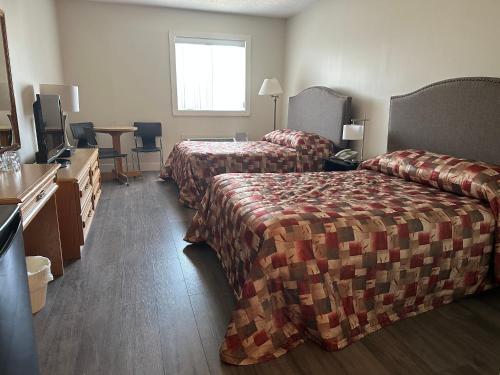 Habitación de hotel con 2 camas y TV en Condos Vacances MSA AVEC PISCINE ET SPAS OUVERTS À L'ANNÉE INCLUS, en Beaupré