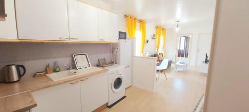 a kitchen with white cabinets and a washer at Le Petit Martin ~T2 cosy ~ Netflix ~ Parking ~ Animaux bienvenus 