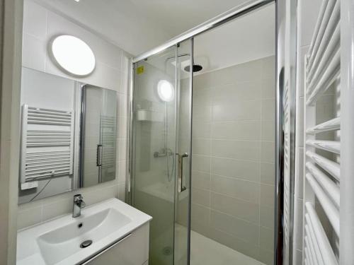 une salle de bain avec un lavabo et une douche en verre dans l'établissement AZUR Reims au bord de l'eau - Avec Parking, à Reims