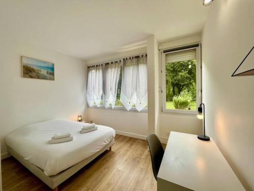 une chambre avec un lit, un bureau et une fenêtre dans l'établissement AZUR Reims au bord de l'eau - Avec Parking, à Reims