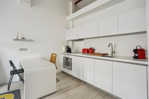 a white kitchen with white cabinets and a sink at New Apartment near Champs Elysées in Paris