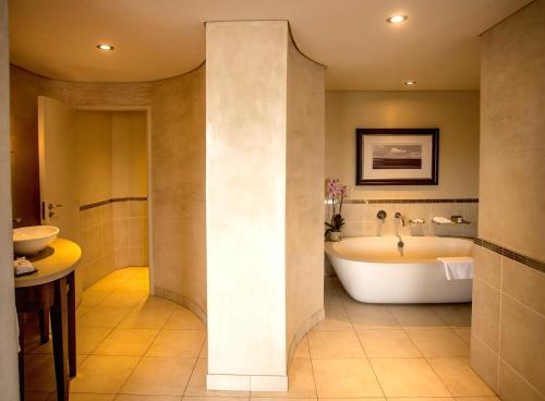 a bathroom with a tub and a sink at Southern Sun Pretoria in Pretoria
