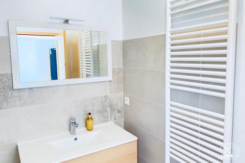 La salle de bains est pourvue d'un lavabo et d'un miroir. dans l'établissement Ty Maneguy - Maison neuve et confortable, à Vannes