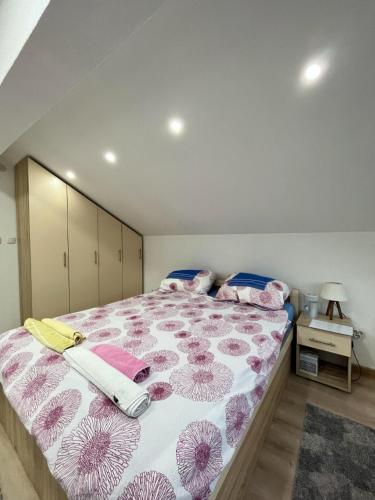 a bedroom with a large bed with pink flowers on it at Vikendica Teodora - Zvornik in Zvornik