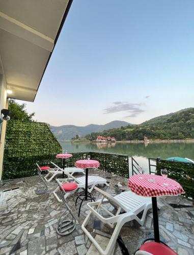 a patio with tables and chairs and a view of a lake at Vikendica Teodora - Zvornik in Zvornik