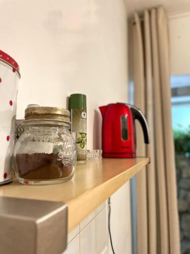 a kitchen counter with a jar of food and a red appliance at פסק זמן in Ramat Shlomo