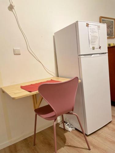 a desk with a chair next to a refrigerator at פסק זמן in Ramat Shlomo