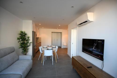 a living room with a couch and a table with chairs at Duerming Sanxenxo Silgar VUT in Sanxenxo