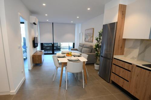 a kitchen and living room with a table and chairs at Duerming Sanxenxo Silgar VUT in Sanxenxo