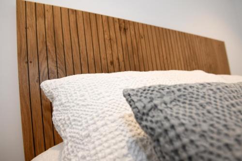 a bed with a wooden head board and a pillow at Duerming Sanxenxo Silgar VUT in Sanxenxo
