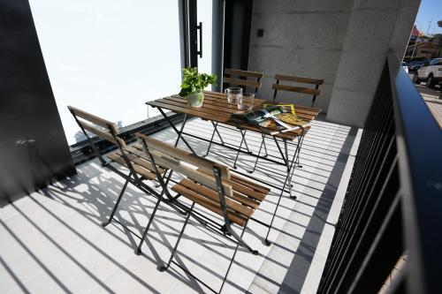 a table and chairs on top of a balcony at Duerming Sanxenxo Silgar VUT in Sanxenxo