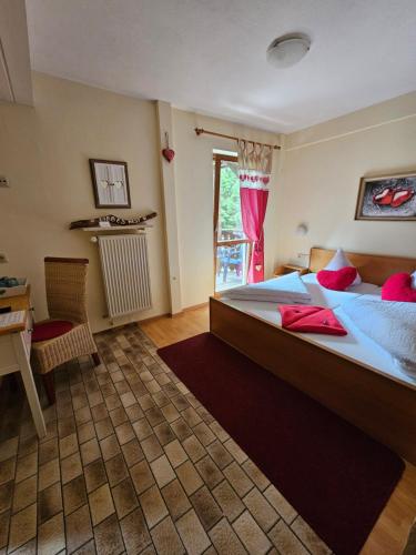 a bedroom with a large bed and a table and a window at Pension Schatzkisterl in Zwiesel