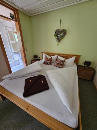 a bedroom with two beds with white sheets and brown pillows at Pension Schatzkisterl in Zwiesel