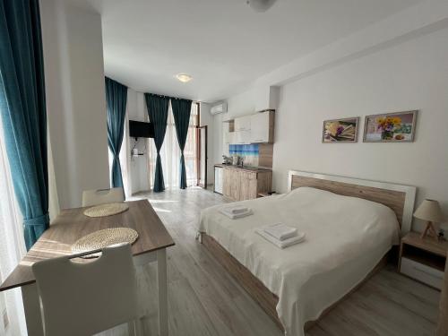 a bedroom with a bed and a table and a kitchen at Studio Maria Balchik in Balchik