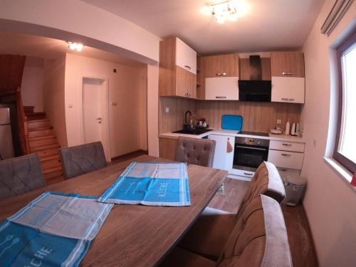 cocina con mesa de madera en una habitación en villa rayan, en Hadžići