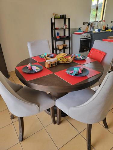 a dining room table with white chairs and a table with food on it at Villa Teresita - vista hermosa in Coco
