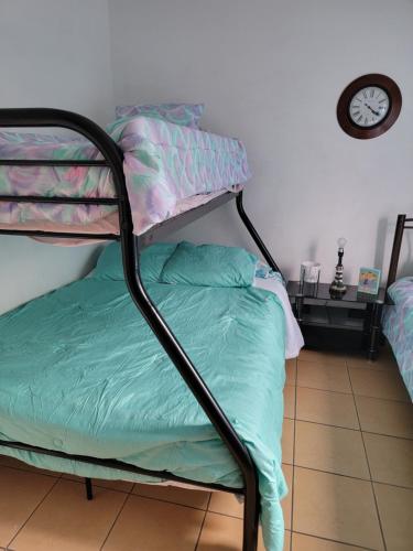 a bunk bed in a room with a clock at Villa Teresita - vista hermosa in Coco