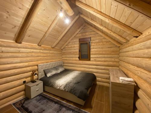 een slaapkamer in een blokhut met een bed erin bij Ethno House Bektesevic in Gusinje
