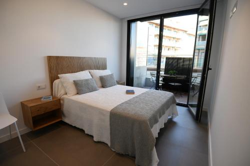 a bedroom with a bed and a large window at Duerming Sanxenxo Silgar VUT in Sanxenxo