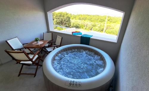 a large bath tub in a room with a window at Dubrovnik Airport Apartment Tea in Durovići