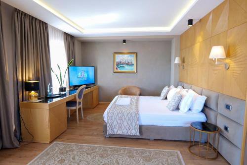 Habitación de hotel con cama y escritorio en Kodra e Kuajve en Durrës