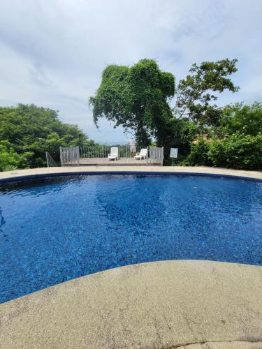 a swimming pool with blue water in a yard at Villa Teresita - vista hermosa in Coco