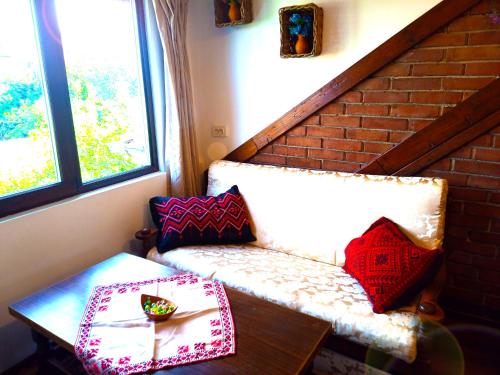Habitación con banco y mesa con almohadas en Ethno art maisonette in the center of Sofia, en Sofía