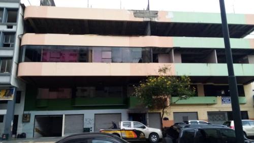 un edificio con coches estacionados frente a él en HOTEL LAS CAPERUZAS, en Guayaquil