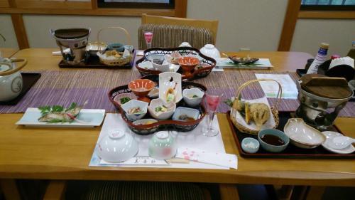 a wooden table with dishes and bowls on it at Miyoshino Sakuraan in Yoshino