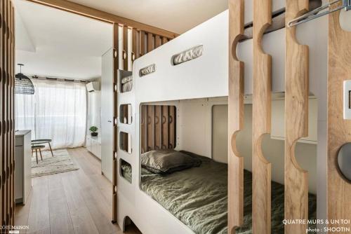 um quarto com um beliche com divisórias de madeira em Magnifique Studio - Beach Side Bliss em La Grande-Motte