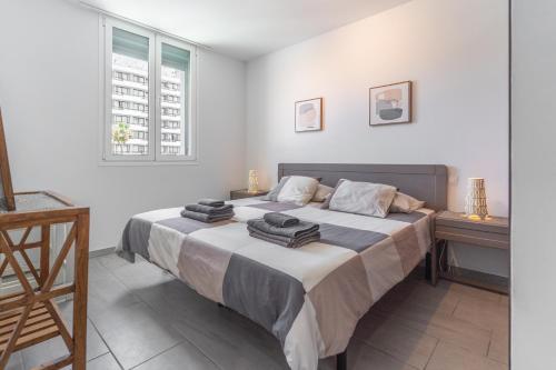 a bedroom with a large bed with towels on it at GO2TENERIFE Apart'Teno Amazing pool view & near the beach in Playa de las Americas