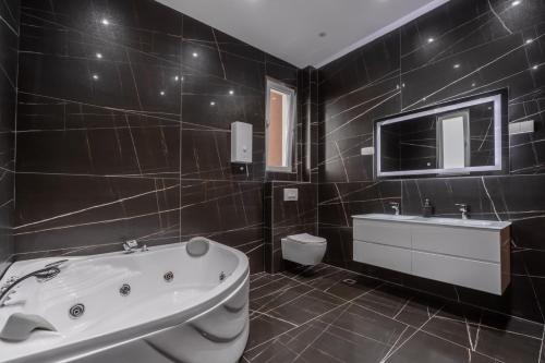 a bathroom with a tub and a toilet and a sink at Villa La Reina in Bar